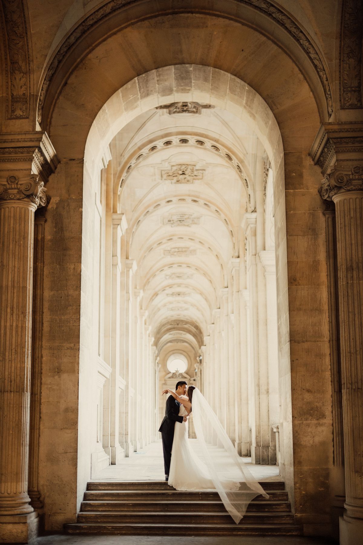 Bride walking through elegant Paris architecture louvre during an elopement photoshoot