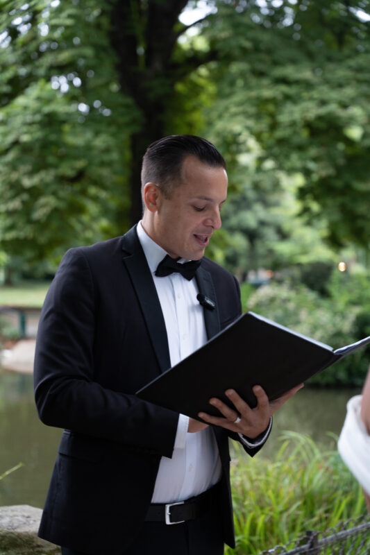 Wedding officiant reading vows during an elopement ceremony in Parc Monceau Paris