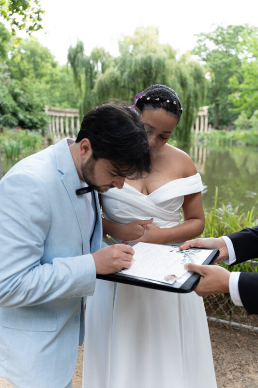 Groom signing wedding documents during an intimate elopement in Parc Monceau Paris