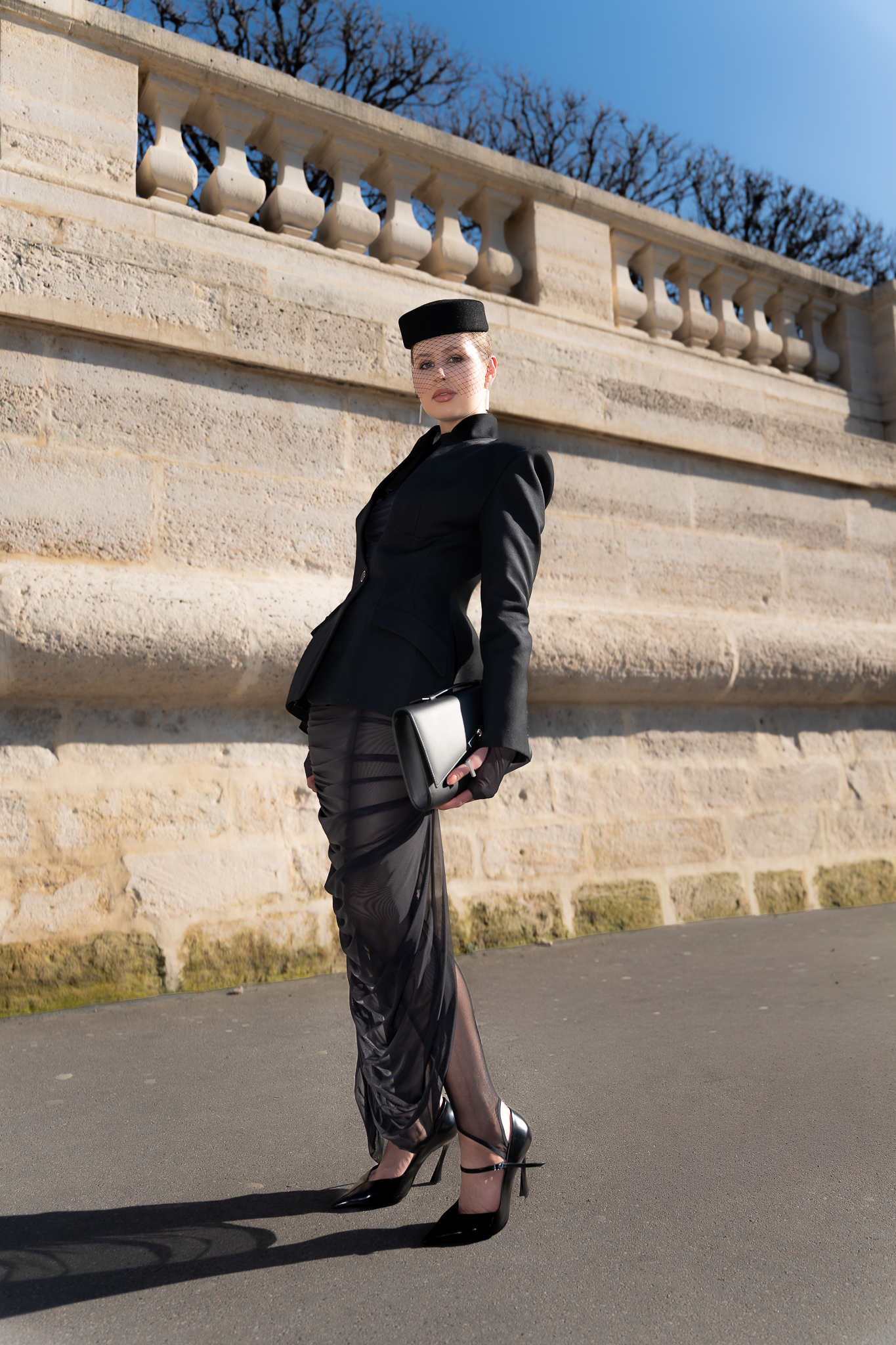Side portrait of a client in a black outfit during Paris Fashion Week