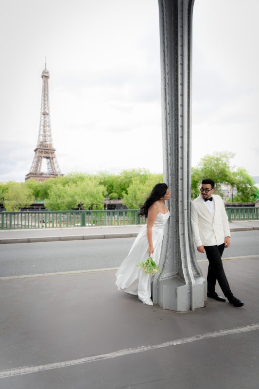 Bride and groom walking at Bir-Hakeim with the Eiffel Tower in the background