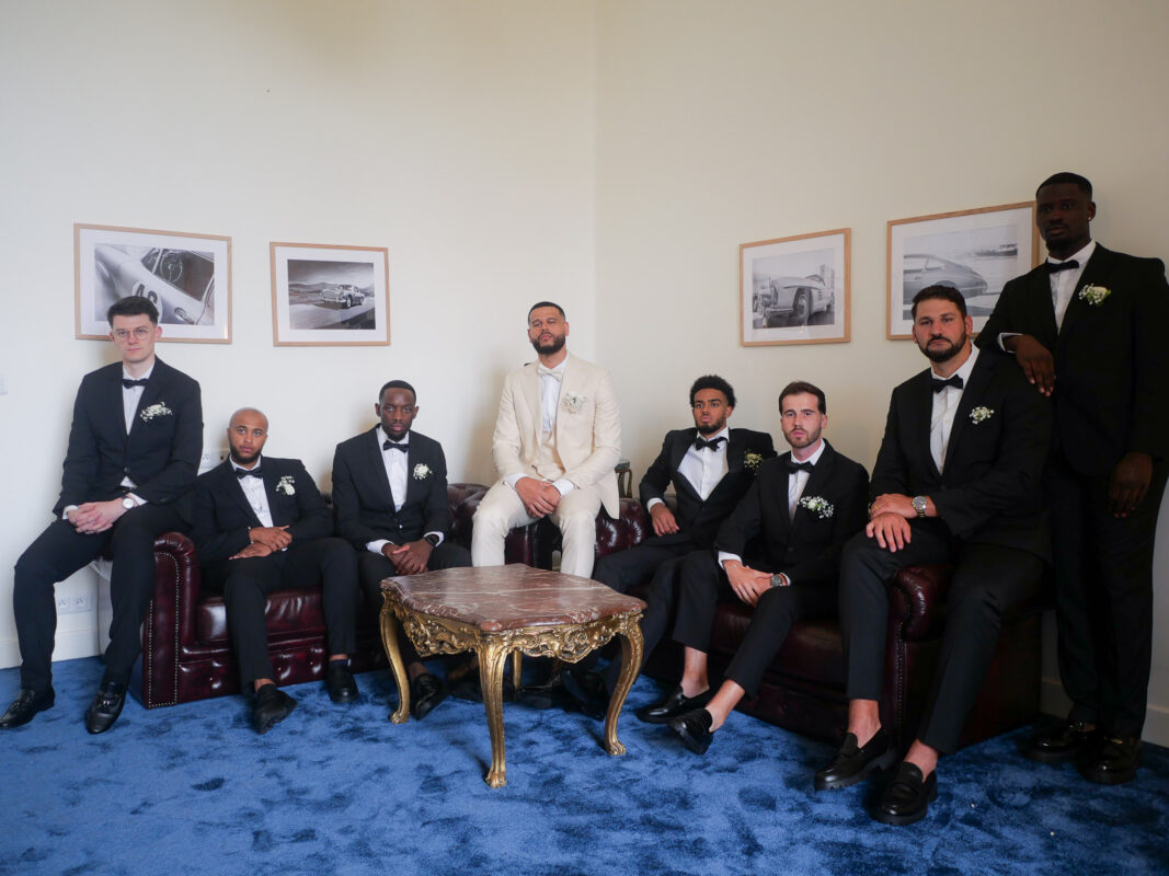 Groom seated with groomsmen inside Château de Saint-Martin-du-Tertre