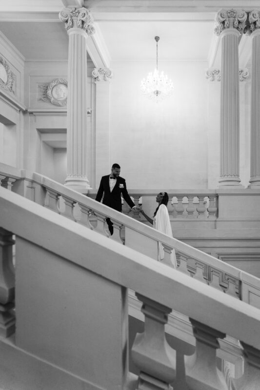 Black-and-white portrait of the bride and groom on the staircase at Château de Saint-Martin-du-Tertre