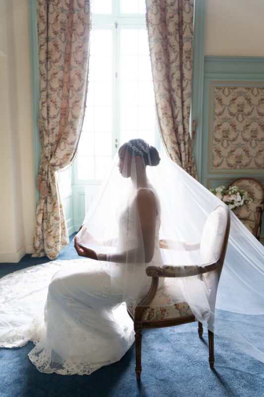 Black-and-white side profile of the bride wearing a veil by the window