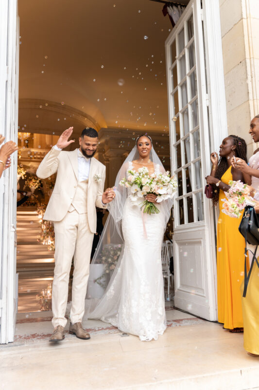 Bride and groom walking out of the château during their luxury wedding celebration