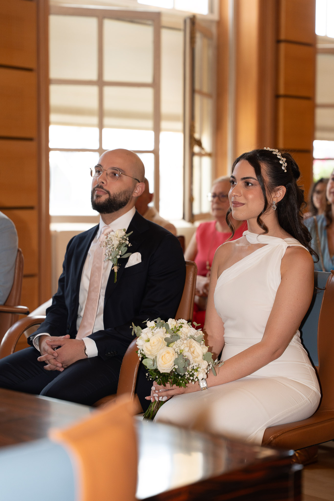 Bride and groom seated during their civil ceremony at Suresnes City Hall