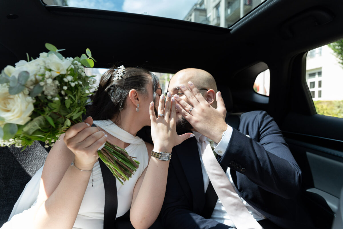 Bride and groom sharing an intimate moment in a car after their wedding in Suresnes