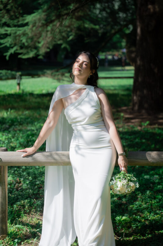 Bride leaning on a wooden fence during her wedding portrait session in Suresnes
