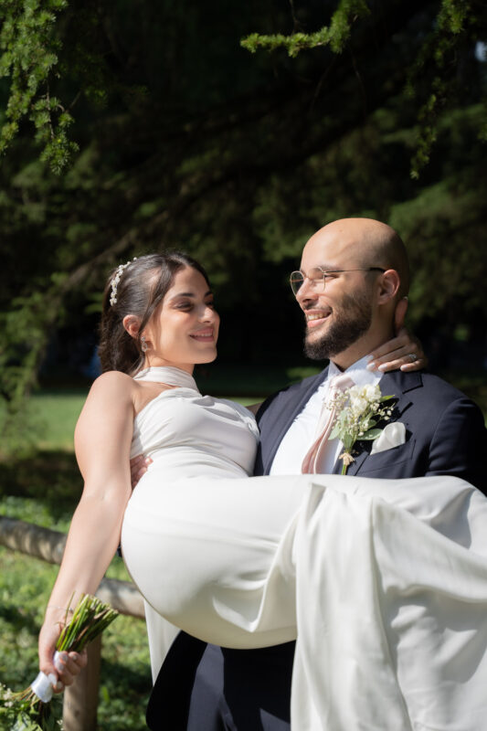 Groom holding the bride in a park after their wedding in Île-de-France