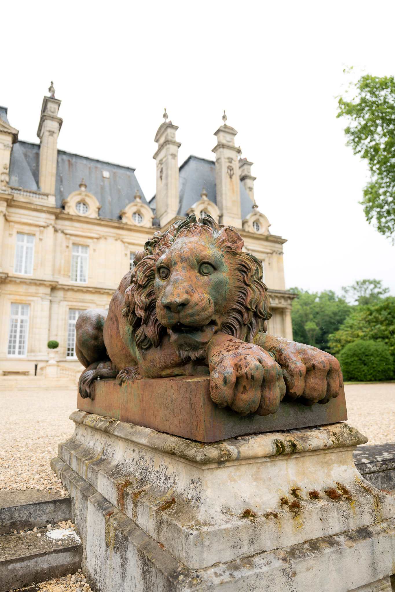 Lion statue outside Château de Saint-Martin-du-Tertre during a luxury wedding in Île-de-France