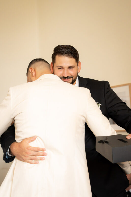 Groom greeting a guest during wedding preparations at Château de Saint-Martin-du-Tertre